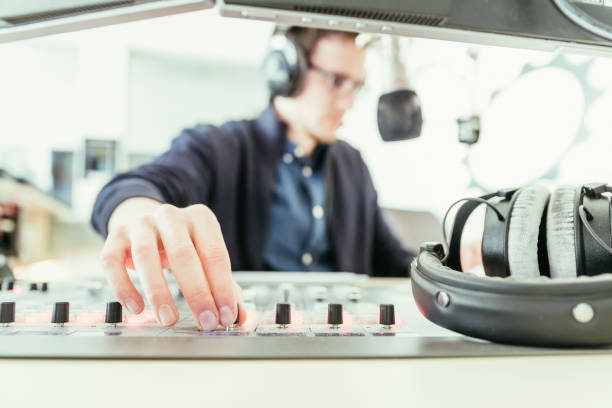 istock Radio moderator is sitting in a modern broadcasting studio and talking into the microphone 1142589894