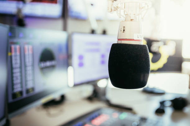 istock Radio broadcasting studio: Microphone in the foreground, modern studio in the blurry background 1142589923
