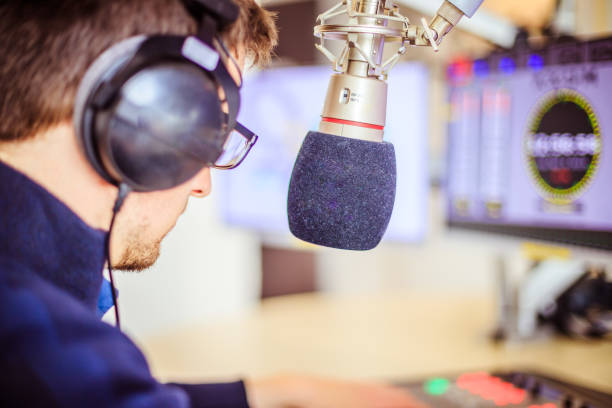 istock Radio moderator is sitting in a modern broadcasting studio and talking into the microphone 1142589928