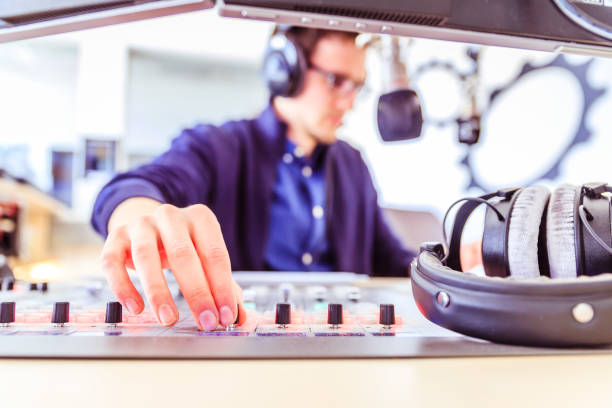 istock Radio moderator is sitting in a modern broadcasting studio and talking into the microphone 1142589941
