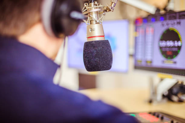 istock Radio moderator is sitting in a modern broadcasting studio and talking into the microphone 1142589950
