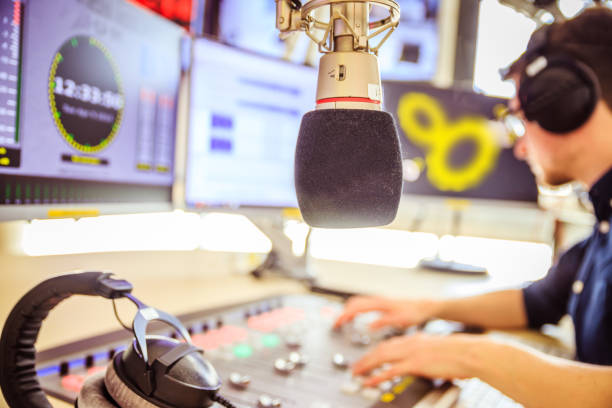 istock Radio moderator is sitting in a modern broadcasting studio and talking into the microphone 1142589972