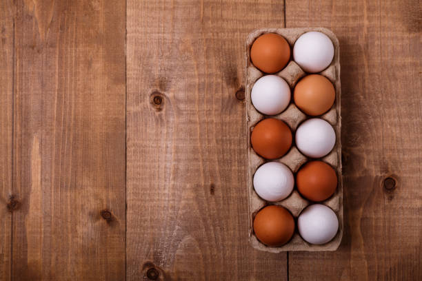 istock Eggs in pack on wooden table. Top view, text space 1142590158