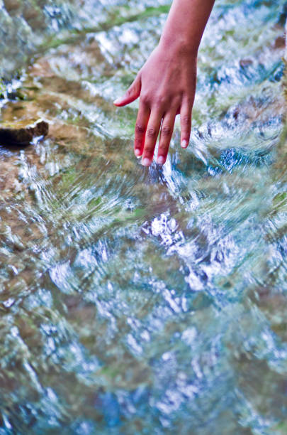 istock hand touching water, source of life 1142592615