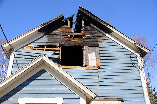 Blue wooden home with the roof burned away Old Home Burns Down Fire Damage Repair.