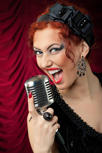 istock beautiful redhead woman singing into vintage microphone 114260578