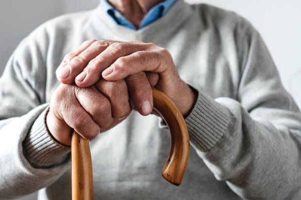istock Hands of an elderly man resting on a walking cane 1142606810