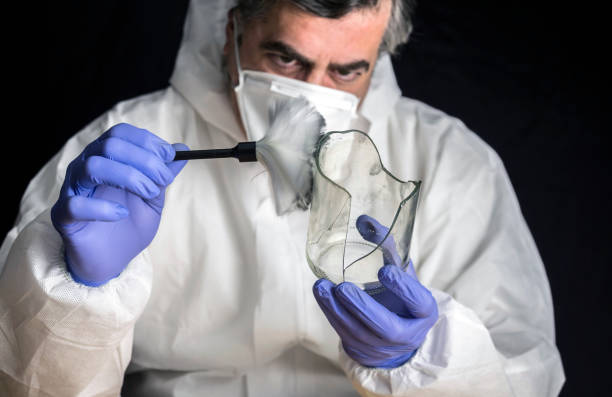 Expert Police get fingerprints from a broken glass bottle in Criminalistic Lab, conceptual image stock photo