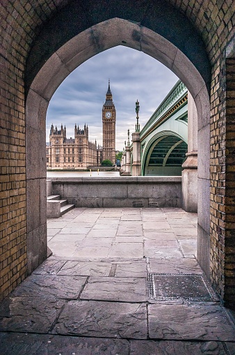 View through the archway under the bridge to Westminster, London, including Westminster Palace (Houses of Parliament), Big Ben and Westminster Bridge.