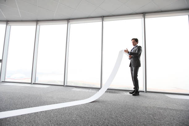 Businessman reading long paper list stock photo