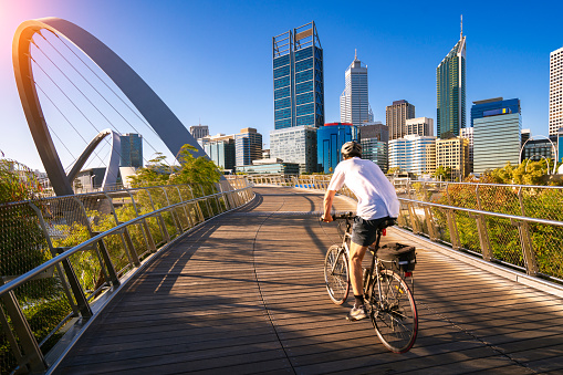 A man cycling on an elizabeth bridge in Perth city, western, Austrakia, this image can use for bike, sport, relax, healthy concept