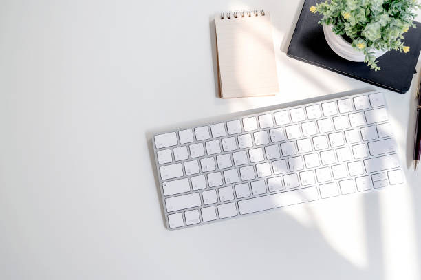 istock Mockup white keyboard and supplies on white table. 1142615272