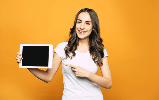 istock This is what you need! Modern white colored tablet PC with great properties in the hand of gorgeous young girl in basic white T-shirt and brilliant smile all over her face. 1142617208