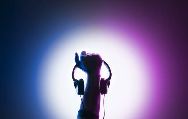 Raised male hand. Headphones in hand.