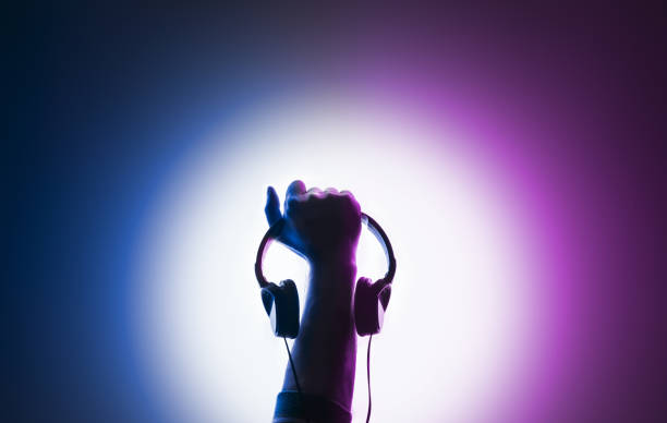 Raised male hand. Headphones in hand Raised male hand. Headphones in hand. dance  electronic music photos stock pictures, royalty-free photos & images