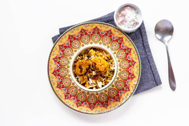 халяль индийской курицы biryani подается с йогуртом томатной raita на белом фоне. селективный фокус. - clipping path rice white rice basmati rice стоковые фото и изображ�ения