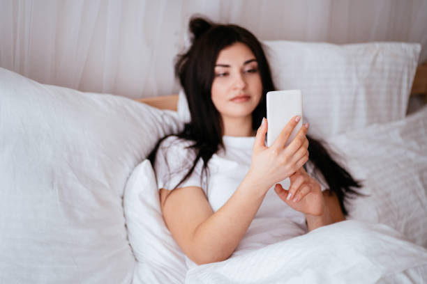 istock Relaxed woman using a smart phone at home bed 1142619342