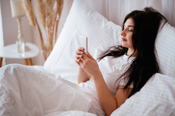 istock Relaxed woman using a smart phone at home bed 1142619345