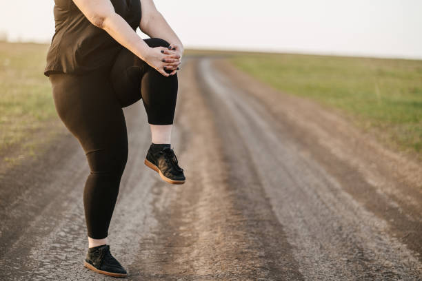 istock Overweight woman training legs before jogging 1142619376