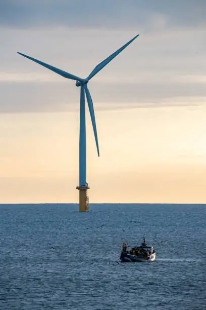 Fishing boat in the north sea near the wind farm turbines at redcar