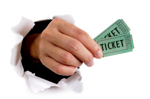 Man's hand with green tickets bursting through a white paper background.  Alternative version shown below: