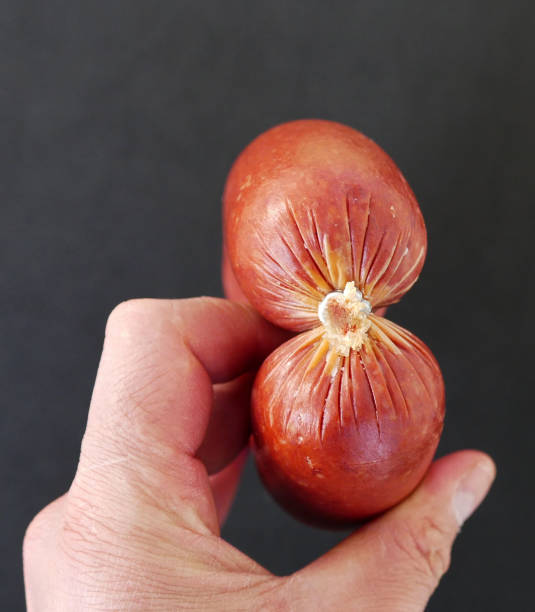 there is a thick coiled sausage in the hands of a man,