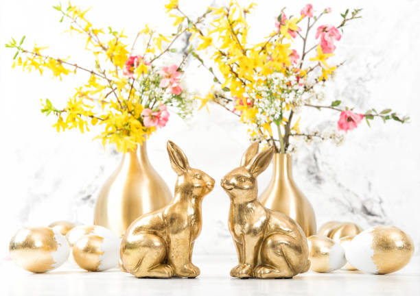istock Easter bunnies golden eggs flowers decoration 1142626395