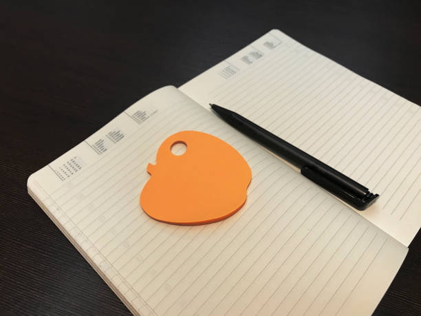 istock Opened notebook with orange sticky memo and pen 1142628204