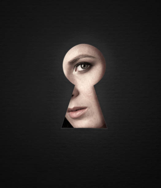 A look through the keyhole of the girl, emotions and makeup. The girl is curious, emotionally peeping into the keyhole. Good idea to post. woman spying through a keyhole stock pictures, royalty-free photos & images