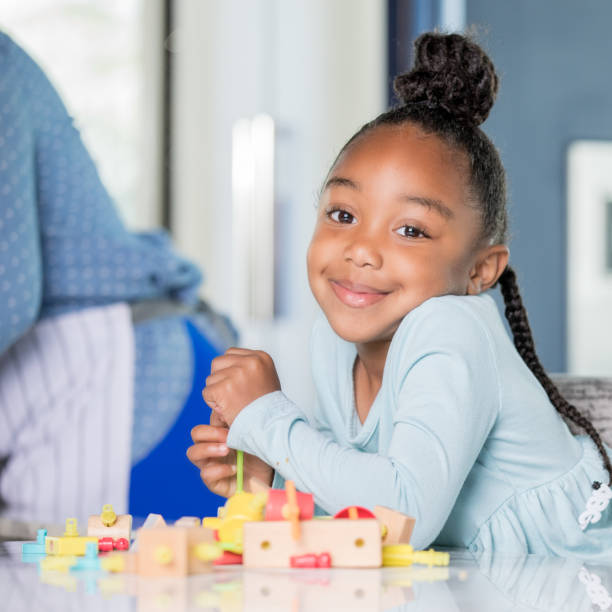istock African-American female child smiling while playing with blocks 1142630045
