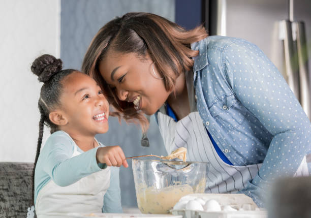 istock Mother and daughter laughing while baking 1142630063