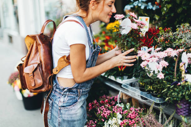 junge frauen kaufen blumen auf dem markt - flower shop stock-fotos und bilder