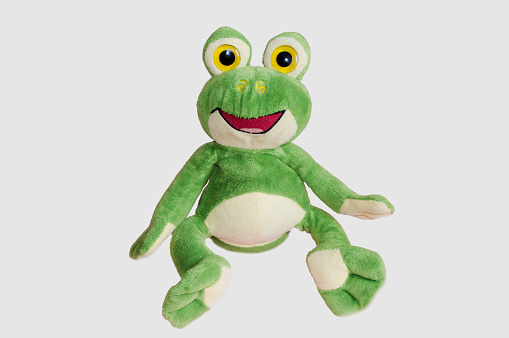 Toy soft cheerful green frog on a white background