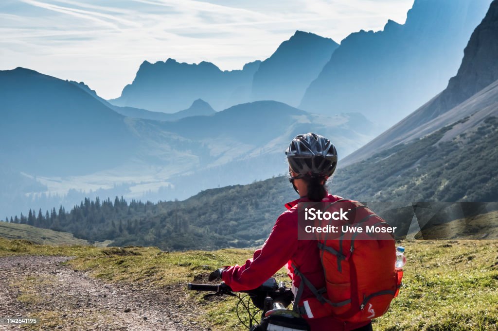 Mountainbiking in The Karwendel mountains senior woman, riding her electrical mountain bike in the Karwendel area below the Laliderer Walls, Tirol,Austria Mountain Biking Stock Photo