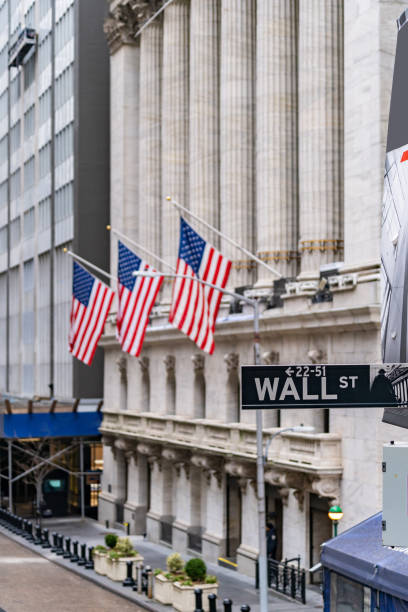 Wall street Wall street sign with New York Stock Exchange background New York City, New York, USA. wall street lower manhattan photos stock pictures, royalty-free photos & images