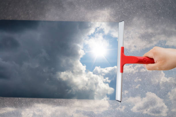 istock Man removing dirt from glass with a squeegee 1142646097