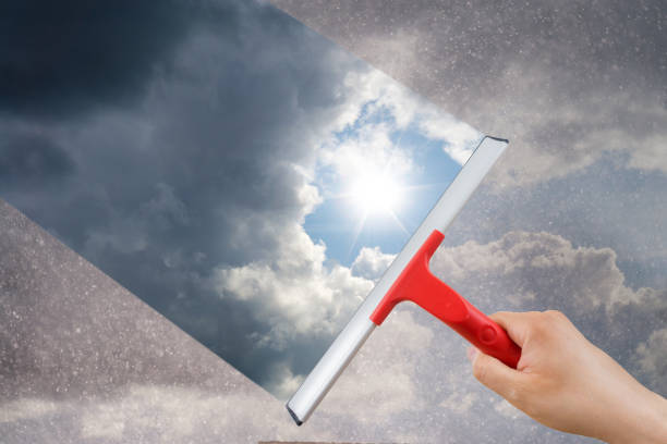 istock Man removing dirt from glass with a squeegee 1142646152