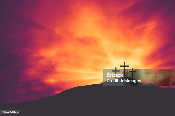 Three Christian Easter And Good Friday Holiday Crosses On Hill Of Calvary With Colorful Clouds In Sky Background Stock Photo - Download Image Now