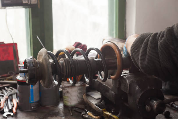 istock mechanic working on used car shock absorber 1142651750