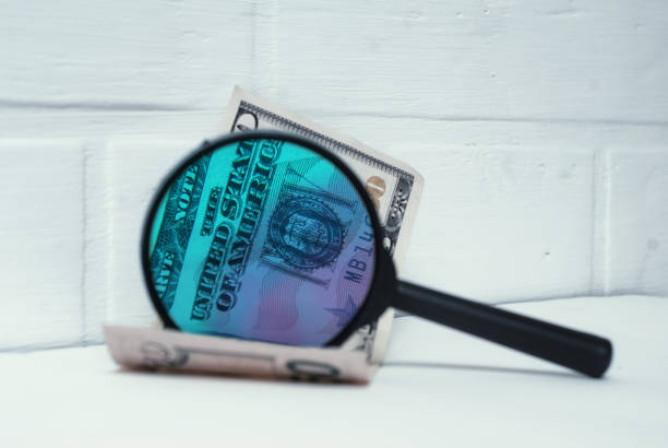 偽物のためにドルをチェック.紙幣の背景にガラスを拡大鏡。 - imitation currency white collar crime discovery ストックフォトと画像