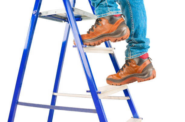 istock Man climbing on metal ladder isolated on white background 1142652363