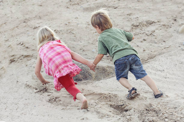istock Children play together and overcome difficulties. Help concept outdoor 1142653047