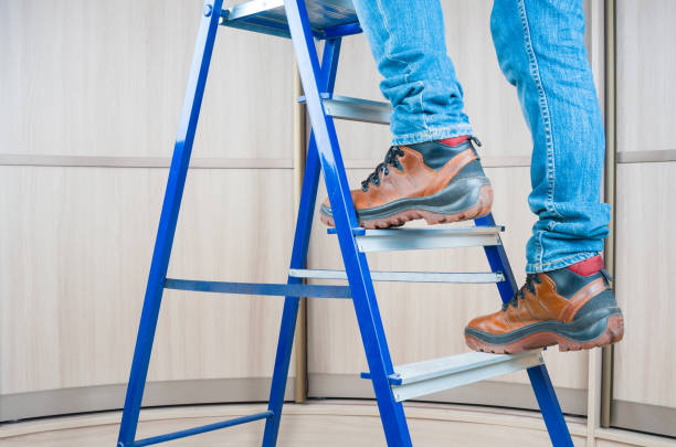 handyman subiendo en escalera de acero interior - ladder fotografías e imágenes de stock
