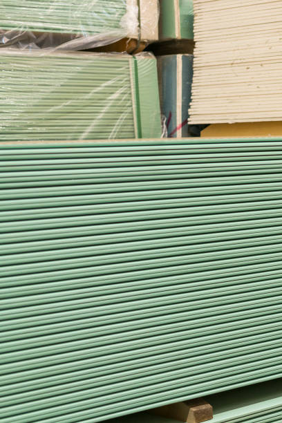istock Gypsum plasterboard in the pack. The stack of gypsum board preparing for construction. Pallet with plasterboard in the building store. Construction Materials. Drywall warehouse. vertical photo 1142653936