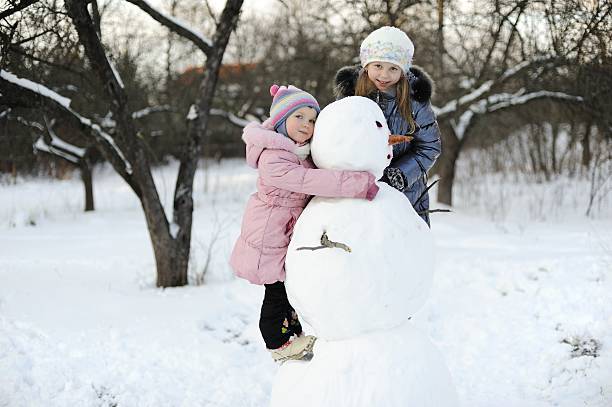 istock Girls with snowman 114265506