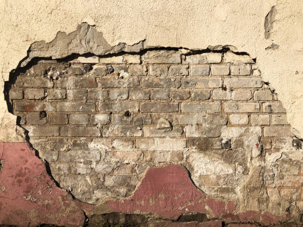 istock Old dirty destroyed brick wall with peeling plaster, cement and paint. 1142655227