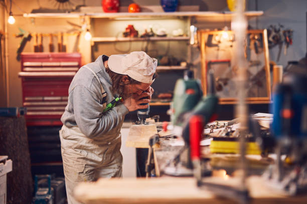 istock Male carpenter working on old wood in a retro vintage workshop. 1142658806