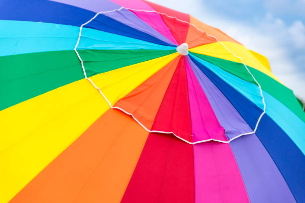 Colorful beach umbrella cloth background texture. Rays of the summer sun. Travel and tourism. Rest and vacation