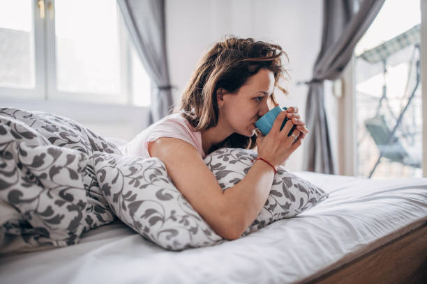 istock Young woman is drinking coffee in her bed 1142659971