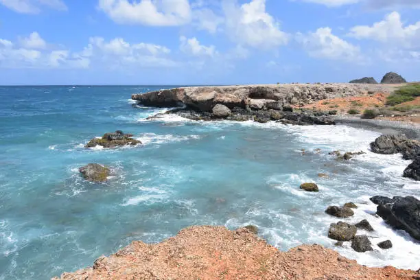 Black stone beach with aqua tropical waters in Aruba.